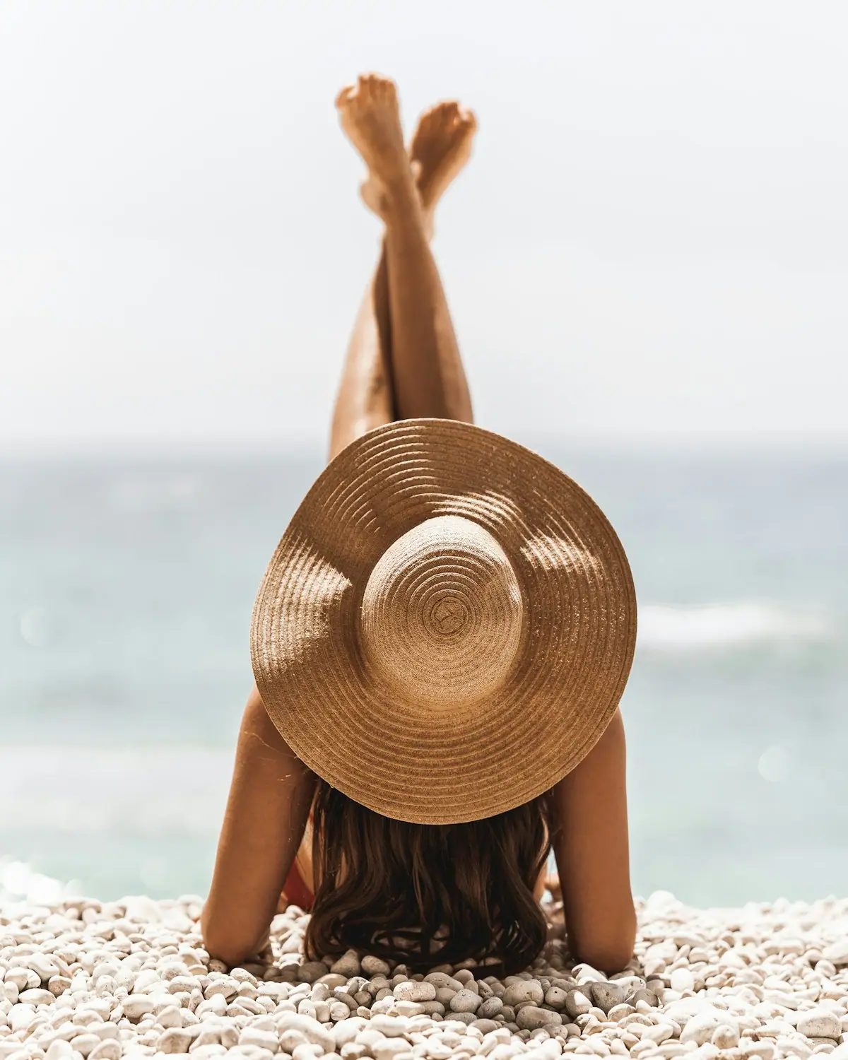 A woman sunbathing on warm sand after time in the water